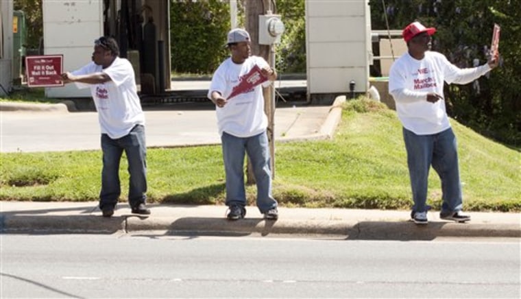 Muslims Edrick Kiser, left, Shawn Lawson, center, and Kamil Speller wave census signs at passing motorists outside a mosque in Charlotte, N.C., on April 10.